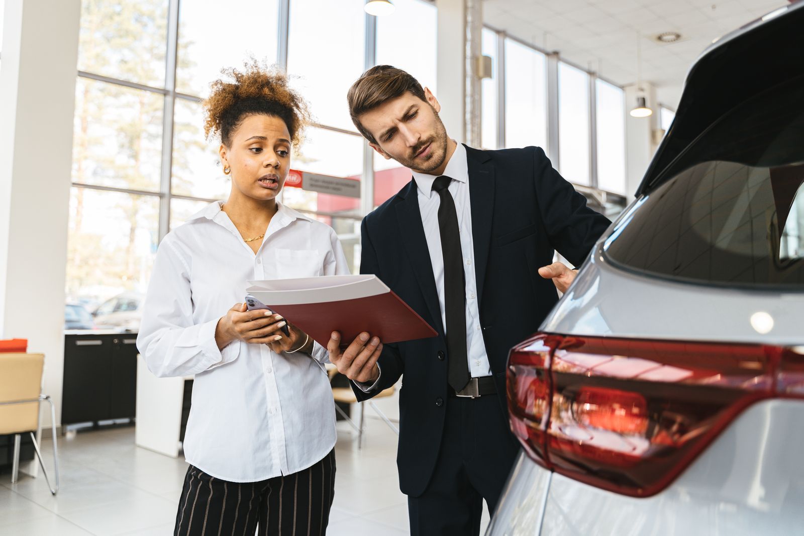 Conducteur lisant les conditions d’une offre de location automobile